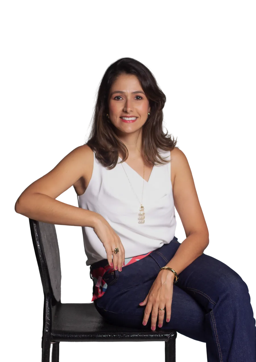 Dra. Izadora Tannus sentada, sorrindo, de blusa branca
